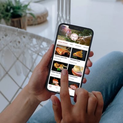 Frau mit Smartphone in der Hand auf der die Derntl Click & Collect App geöffnet ist