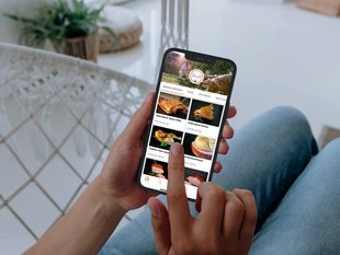 Frau mit Smartphone in der Hand auf der die Derntl Click & Collect App geöffnet ist