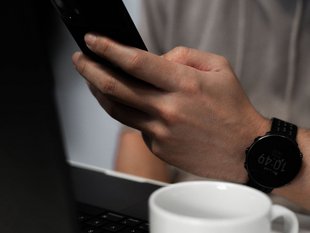 Ausschnitt einer Person mit Laptop und Smartphone