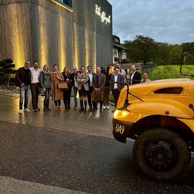 Gruppenfoto der Teilnehmer*innen mit dem gelben Schulbus