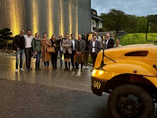 Gruppenfoto der Teilnehmer*innen mit dem gelben Schulbus